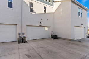 View of side of property featuring stucco siding and a garage