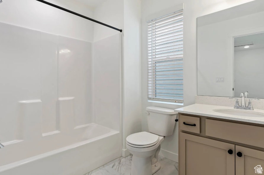 Full bath with marble finish floor, toilet, vanity, and shower / washtub combination