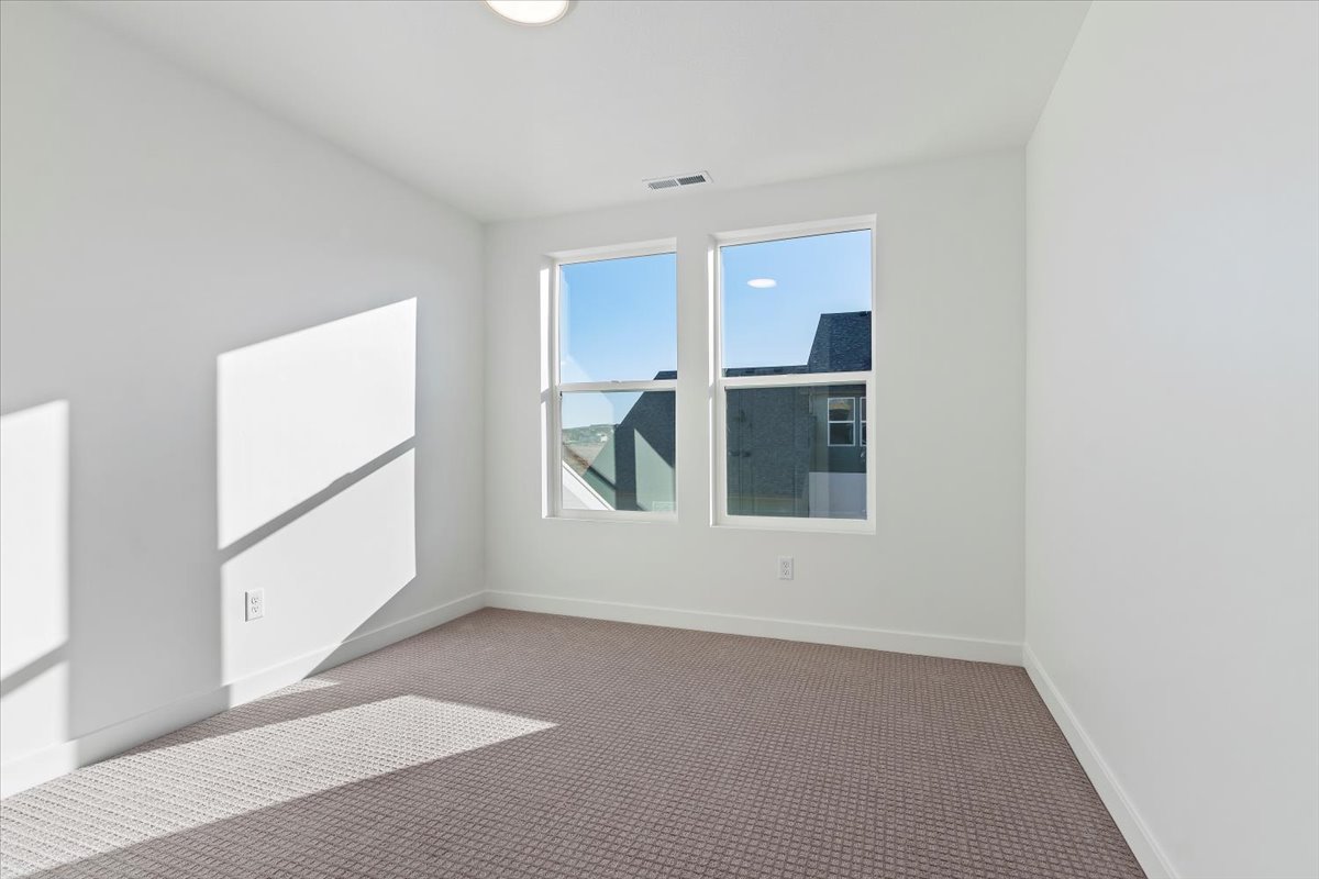 Carpeted spare room with baseboards and visible vents