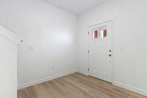 Entryway with baseboards and light wood finished floors