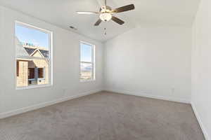 Unfurnished room featuring visible vents, baseboards, a ceiling fan, light carpet, and lofted ceiling