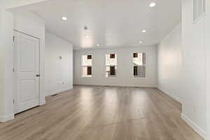Unfurnished living room with baseboards, light wood-type flooring, visible vents, and recessed lighting