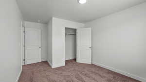 Unfurnished bedroom featuring baseboards, a closet, and carpet