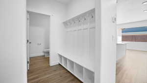 Mudroom featuring baseboards, a textured ceiling, and wood finished floors