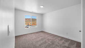 Empty room with baseboards, carpet floors, and a textured ceiling