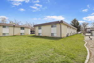 Back of house featuring a yard and brick siding