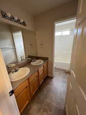 Full bathroom with double vanity, a sink, and tile patterned floors