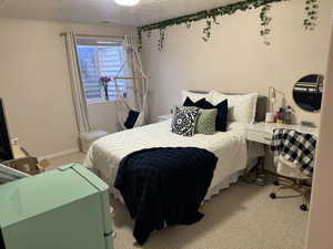 Bedroom with carpet flooring, a textured ceiling, and visible vents