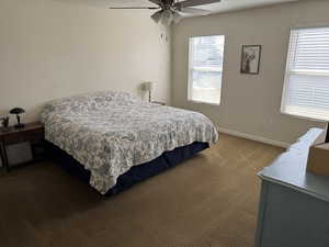 Bedroom featuring baseboards, ceiling fan, and neutral carpet