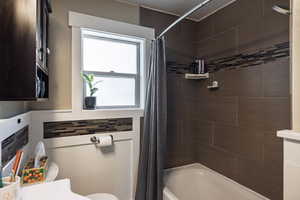 Full bathroom with shower / bath combination with curtain and toilet