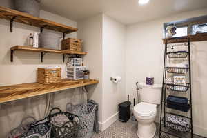 Bathroom with toilet, recessed lighting, tile patterned flooring, and baseboards