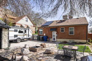 Back of property featuring an outdoor fire pit, a patio, a shingled roof, and brick siding