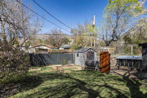 View of yard with exterior structure, an outdoor structure, and fence