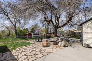 View of patio featuring outdoor dining area, fence private yard, and an outdoor fire pit