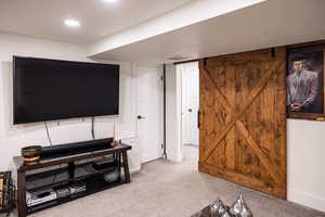 Carpeted living area featuring baseboards, visible vents, and recessed lighting