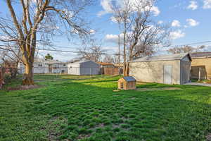 View of yard featuring a fenced backyard, an outbuilding, and a storage shed