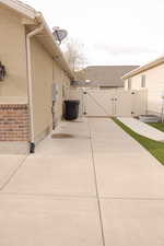 View of home's exterior featuring a patio area, a gate, fence, and stucco siding