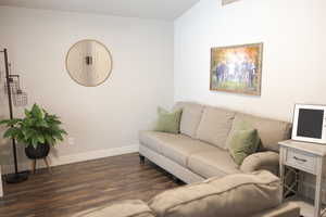 Living area with baseboards and dark wood-style floors