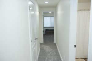 Hall with baseboards and carpet