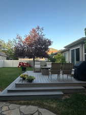 Wooden terrace with a yard, fence, and grilling area