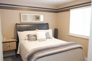 Carpeted bedroom featuring multiple windows