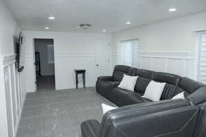 Living room with carpet floors, a textured ceiling, a healthy amount of sunlight, and recessed lighting