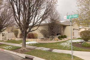 View of front facade featuring stucco siding, fence, and an attached garage