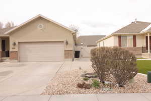 View of front of property with driveway, a gate, and brick siding
