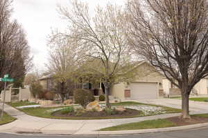 View of front of property with concrete driveway, stucco siding, fence, an attached garage, and brick siding
