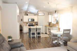 Interior space with vaulted ceiling, recessed lighting, and dark wood-type flooring