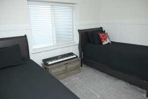 Bedroom with a wainscoted wall and a decorative wall