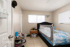 Primary Bedroom featuring light tile patterned floors and Half Bathroom