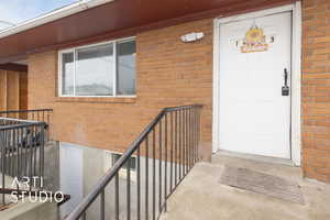 Doorway to property featuring brick siding