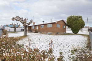 Snow covered back of property with fence