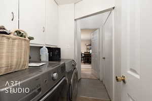 Clothes washing area with cabinet space, separate washer and dryer, and light tile patterned floors