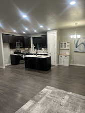 Kitchen featuring baseboards, an inviting chandelier, light countertops, recessed lighting, and stainless steel appliances