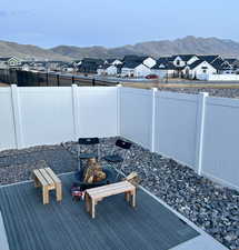 Exterior space featuring a residential view, a fenced backyard, a mountain view, and an outdoor fire pit