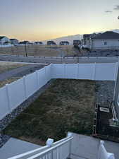 Yard at dusk with a fenced backyard