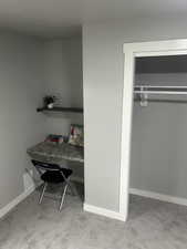 Bed 4 featuring built in custom desk and shelf, carpet flooring and baseboards