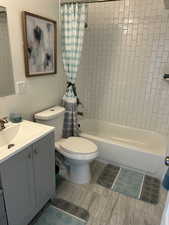 Full Bathroom featuring shower / tub combo with curtain, vanity, and toilet