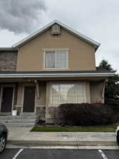 View of front facade featuring stone siding and stucco siding