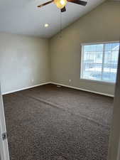 Carpeted empty room with baseboards, lofted ceiling, and a ceiling fan
