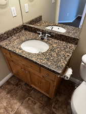 Bathroom with baseboards, toilet, and vanity