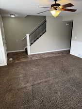 Unfurnished living room featuring a textured ceiling, visible vents, stairway, a ceiling fan, and carpet floors