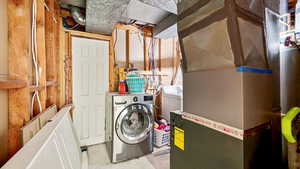 Laundry room featuring heating unit, independent washer and dryer, and laundry area