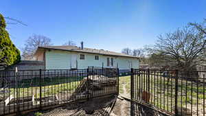 Back of house with a yard, fence, french doors, and a vegetable garden