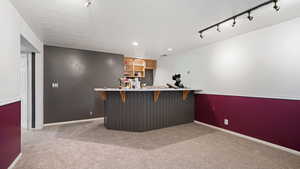 Bar with a bar, carpet floors, baseboards, and recessed lighting