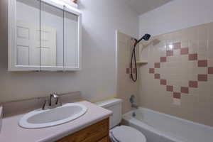 Full bathroom featuring toilet, vanity, and  shower combination