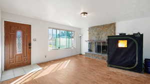 Foyer entrance with baseboards, a fireplace, and wood finished floors