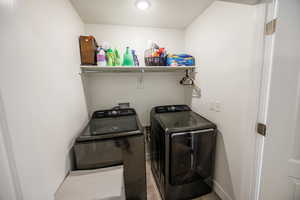 Laundry room with washing machine and clothes dryer, baseboards, and laundry area